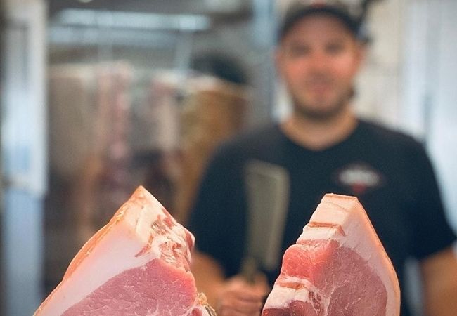 Lennart Hermstein mit Fleisch im Vordergrund - Fleischerei Münch